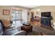 Comfortable living room showcasing hardwood floors, stylish rug, and access to the backyard at 1702 Cordova Green, Seminole, FL 33777