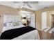 Cozy bedroom featuring a white comforter, ceiling fan, and access to en-suite bathroom at 1702 Cordova Green, Seminole, FL 33777