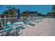 Pool deck with lounge chairs, tables, and lush landscaping with community building in the background at 1702 Cordova Green, Seminole, FL 33777