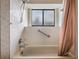 Bathroom featuring a bathtub with shower and a window providing natural light at 1912 Blue Sage Ct, Brandon, FL 33511