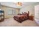 Cozy bedroom with a ceiling fan, carpet flooring, and a window for natural light at 1912 Blue Sage Ct, Brandon, FL 33511