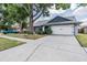Home showcasing an attached two-car garage, front yard landscaping, and mature shade trees at 1912 Blue Sage Ct, Brandon, FL 33511