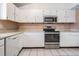 Efficient kitchen featuring white cabinets, stainless steel appliances, and neutral countertops at 1912 Blue Sage Ct, Brandon, FL 33511