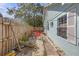 Quaint backyard with a stone path, red patio furniture, and a wood fence at 2014 E Broad St, Tampa, FL 33610