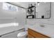 Bright bathroom featuring a tub with glass doors, a white tile wall, and modern decor at 2014 E Broad St, Tampa, FL 33610