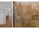 Shower featuring updated stone-look tile, glass door, and a seating area at 2014 E Broad St, Tampa, FL 33610