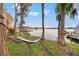 Relaxing backyard scene with a hammock strung between trees, overlooking the serene waterfront at 21918 Shamu Dr, Land O Lakes, FL 34639