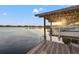 Picturesque boathouse featuring a boat lift and scenic lake views at sunset at 21918 Shamu Dr, Land O Lakes, FL 34639