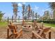 Cozy outdoor fire pit surrounded by Adirondack chairs, perfect for entertaining with a view of the pool and lake at 21918 Shamu Dr, Land O Lakes, FL 34639