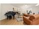 Inviting living room features a stone fireplace, leather furniture, piano, and wood flooring at 21918 Shamu Dr, Land O Lakes, FL 34639