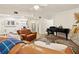 Relaxing living room with leather sofa, fireplace, piano and wood flooring at 21918 Shamu Dr, Land O Lakes, FL 34639
