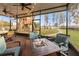 Inviting screened porch with a cozy fire table and picturesque backyard view featuring a custom treehouse at 21918 Shamu Dr, Land O Lakes, FL 34639