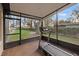 Enclosed porch featuring a treadmill, providing a private exercise area with a view of the scenic yard at 21918 Shamu Dr, Land O Lakes, FL 34639