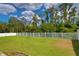Grassy backyard area with perimeter fence line and some trees at 2463 Carnation Ct, North Port, FL 34289