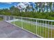 Balcony with white metal railing overlooking green backyard with mature trees at 2463 Carnation Ct, North Port, FL 34289