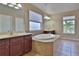 This bathroom features a garden tub with tile surround, dual vanities, and neutral walls at 2463 Carnation Ct, North Port, FL 34289
