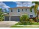 Inviting home featuring a three-car garage and lush tropical landscaping at 2463 Carnation Ct, North Port, FL 34289
