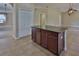 A kitchen island featuring dark wood cabinets and countertop is the focal point of the neutral-toned kitchen at 2463 Carnation Ct, North Port, FL 34289