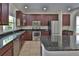 Modern kitchen features granite countertops, dark wood cabinets, and stainless-steel appliances at 2463 Carnation Ct, North Port, FL 34289