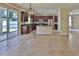 Open-concept kitchen with granite countertops, dark wood cabinets, stainless-steel appliances, and adjacent outdoor access at 2463 Carnation Ct, North Port, FL 34289