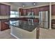 Modern kitchen features granite countertops, dark wood cabinets, and stainless-steel appliances at 2463 Carnation Ct, North Port, FL 34289