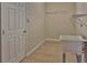 A well-lit laundry room featuring a utility sink, storage shelves, and a door for convenient access at 2463 Carnation Ct, North Port, FL 34289