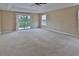 Large main bedroom with carpet flooring, ceiling fan, a window, and sliding glass doors that lead to a balcony at 2463 Carnation Ct, North Port, FL 34289