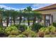Gated community pool and clubhouse behind decorative bushes and palm trees at 2463 Carnation Ct, North Port, FL 34289