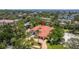 An aerial view of a luxurious estate with a red tile roof, lush landscaping, and sparkling waterfront views, showcasing prime real estate at 2613 N Dundee St, Tampa, FL 33629