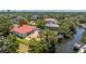 A high angle view highlights a waterfront house with a pool, boat lift, and lush tropical landscaping at 2613 N Dundee St, Tampa, FL 33629