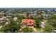 A high-angle aerial view showcases a waterfront estate with a terracotta roof and lush tropical landscaping at 2613 N Dundee St, Tampa, FL 33629
