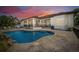 A large backyard pool with a scenic overlook and outdoor seating, perfect for entertaining at 2613 N Dundee St, Tampa, FL 33629