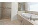 This stylish bathroom features a soaking tub, shower, neutral tile, and a picture window at 2613 N Dundee St, Tampa, FL 33629