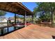 A covered boat dock featuring a boat lift, wooden deck and seating area, perfect for waterfront enjoyment and boating at 2613 N Dundee St, Tampa, FL 33629