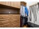 Organized walk-in closet with custom wood built-ins, shelving, drawers, bench and hanging storage at 2613 N Dundee St, Tampa, FL 33629