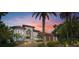 Elegant two-story home with a red tile roof, lush landscaping, and a brick driveway at sunset at 2613 N Dundee St, Tampa, FL 33629