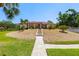 Mediterranean style home featuring manicured front lawn, red tile roof and stone walkway leading to covered porch, offering elegance and curb appeal at 2613 N Dundee St, Tampa, FL 33629