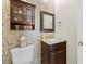 Stylish half bathroom with granite sink, cabinet, mirror, and decorative mosaic tile wall at 2613 N Dundee St, Tampa, FL 33629