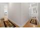Hallway featuring decorative rugs on hardwood floors and doors to multiple rooms and closets at 2613 N Dundee St, Tampa, FL 33629