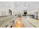 Open concept kitchen with stone countertops and stainless appliances overlooks the dining and living area at 2613 N Dundee St, Tampa, FL 33629