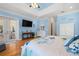 Well-lit main bedroom featuring a tray ceiling, French doors, and an en-suite bathroom at 2613 N Dundee St, Tampa, FL 33629