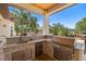 Granite countertop and backsplash enhance this covered outdoor kitchen with stainless steel grill at 2613 N Dundee St, Tampa, FL 33629