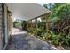 View of the back patio, with hexagon tiles, wooden beams supporting a roof, and a view of greenery at 2719 Boca Ciega N Dr, St Petersburg, FL 33710