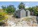 Exterior shot of two storage sheds in the back yard, with a view of surrounding plants and sand at 2719 Boca Ciega N Dr, St Petersburg, FL 33710