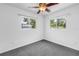 Bright, carpeted bedroom with two windows and white walls at 2719 Boca Ciega N Dr, St Petersburg, FL 33710