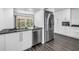 Modern kitchen featuring stainless steel appliances, sleek white cabinetry, and dark countertops, with a view to a garden at 2719 Boca Ciega N Dr, St Petersburg, FL 33710