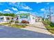 Charming home featuring bright white siding with a vibrant green trim and a spacious driveway at 27466 Us Highway 19 N # 56, Clearwater, FL 33761