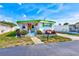 Charming home with white siding, a vibrant green trim, and colorful flower beds at 27466 Us Highway 19 N # 56, Clearwater, FL 33761