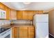 Efficient kitchen features white appliances, wood cabinets, laminate countertops, and modern hardware at 27466 Us Highway 19 N # 56, Clearwater, FL 33761