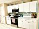 Well-equipped kitchen with white cabinets, stainless steel appliances, and a modern backsplash at 2776 Golf Lake Dr # 1, Plant City, FL 33566